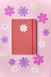 © Noemí Jiménez - Diario rojo cerrado con margarita blanca en portada con flores de papel alrededor, journaling de primavera