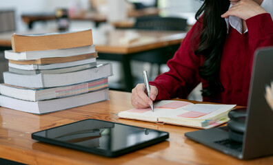 Wall Mural - Businesswoman or student writing note on diary at office desk