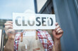 © yurolaitsalbert - cropped image of a male bartender standing with a closed sign.