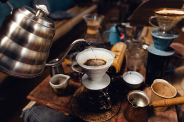 Wall Mural - Man pouring hot water on ground coffee with paper filter to making a drip coffee