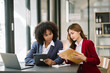 © Nuttapong punna - Two businesswoman discuss investment project working and planning strategy with tablet laptop computer in modern office..