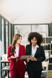 © Nuttapong punna - Businesswomen work and discuss their business plans. A Human employee explains and shows her colleague the results paper in modern office..