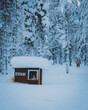 Husky dog house in ice cold snowy arctic winter time where dog freezes and chills in his cabin