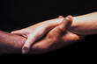 © Cavan Images - Male and female hands with different skin tones holding each other