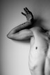 © Cavan Images - Close-up view of nude man curved body and hand. Black and white