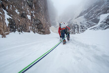 Ice Climber Climbing Snow To Get To Rock Wall