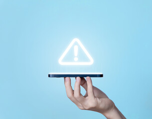 Wall Mural - hand holding smartphone showing warning triangle and exclamation sign icon warning of dangerous prob
