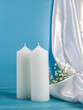 Two white candles on a blue wooden table