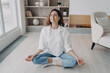 © VK Studio - Girl is sitting in lotus pose with her eyes closed. Stress relief, wellbeing and peace concept.
