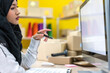 © Art_Photo - Muslim asian woman freelancer sme business online shopping working and checklist order with cardboard box on table at home - Business online shipping and delivery concept