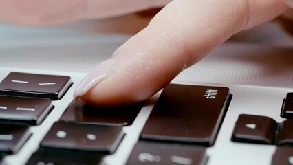 Slow motion, woman's finger pushing button enter on laptop keyboard, concept of e-commerce. Selling and buying items by internet.