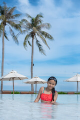 Wall Mural - Happy girl enjoying summer vacations in a pool. Summer holidays, children's swimming, Pool woman on holidays in tropical resort swimming. summer vacation concept.
