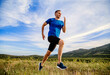 © sports photos - man runner running summer mountain meadow in background blue sky