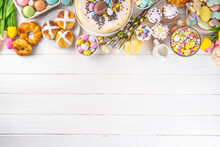 Easter Brunch, Breakfast Food, Kids Easter Party Buffet. Various Traditional Easter Sweets, Candy, Pasties And Baking - Cross Buns, Cheesecake, Chocolate Eggs, Pancakes, Cupcakes, Top View Copy Space