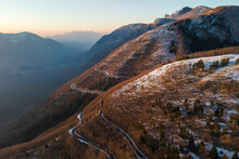 Aerial View Of A Scenic Forest Road On Mountainside In Wintertime At Sunset With Snow On Mount Terminio, Serino, Avellino, Irpinia, Campania, Italy.