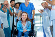 © Halfpoint - Medical staff clapping to little girl patient who recovered from serious illness.