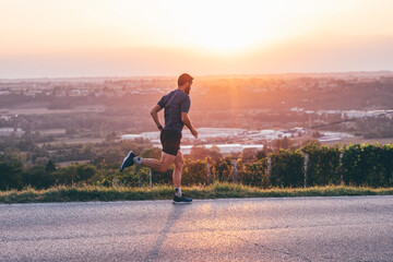 Wall Mural - man running in the countryside at the sunset