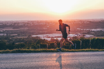 Wall Mural - man running in the countryside at the sunset