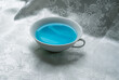 blue drink in a white cup on beautiful white silk cloth