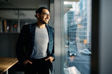 Wall Mural - Happy Latin American businessman enjoys the window through window from his office.