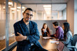 © Drazen - Confident Hispanic businessman with arms crossed on meeting looking at camera.