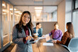 © Drazen - Happy Asian CEO having business meeting with her colleagues in office and looking at camera.