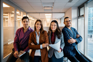 Multiracial group of happy business coworkers in office looking at camera.