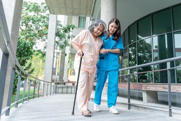 Wall Mural - Asian woman doctor shook hands, encouraged and supported elderly woman patient, Which holds a cane for help support to walking. to  health insurance and osteoarthritis concept.