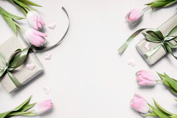 Wall Mural -  festive layout with tulips and a gift with green ribbons on a grey background. copy space. top view. flat lay. concept of mother's day, valentines day, eighth of march