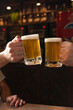 two hands toasting beer mugs