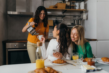 Wall Mural - Best friends are eating croissants and talking at home