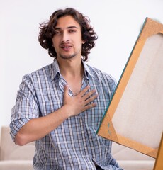 Wall Mural - Young handsome man enjoying painting at home