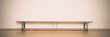 © Bonsales - Empty long wooden bench stands on brown colored parquet floor against blank white concrete wall panoramic front view