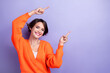 Photo of cute glad cheerful lady wear trendy clothes two arm above head direct empty space banner news isolated on purple color background