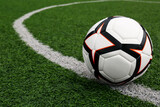 Fototapeta Sport - Soccer ball on green football field, space for text