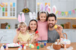 © New Africa - Happy family painting Easter eggs at table in kitchen