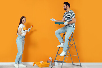 Poster - Designers with painting equipment near freshly painted wall indoors