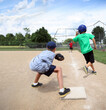 © soupstock - Baseball practice, coach throwing to third base catching runner in a pickle, focus on runner in green