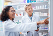 © Nina Lawrenson/peopleimages.com - Pharmacy women, shelf and pointing together with smile, stock and product for medical wellness in store. Pharmacist training, management and teamwork for medicine, service and healthcare in shop
