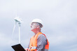 © Cavan Images - older energy engineer in front of a windmill
