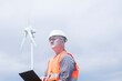 © Cavan Images - older energy engineer in front of a wind turbine