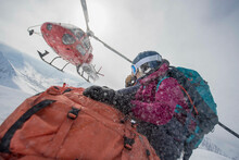 A Female Skier Being Dropped Off By A Helicopter.