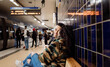© Cavan Images - couple sitting in the subway station waiting for a train together