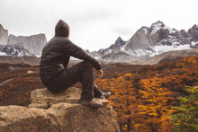 Hiker Sitting On Stone In Mountains During Autumn
