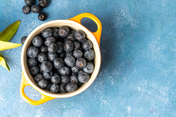 Wall Mural - Blueberries, fresh berry in glass bowl, blue background, top view, copy space