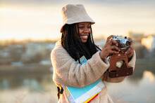 Tourist african american woman with camera taking photos of beautiful location, she's happy and excited about visiting new city