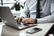 © Visual Studio - Businessman working on laptop computer on white table at office. Professional business man hands typing on laptop, online working, surfing the internet, close up