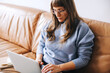 © (JLco) Julia Amaral - Focused businesswoman working on a laptop in an office lobby