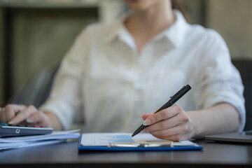  Close-up hand businesswomen using a pen for work.