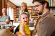 © Austockphoto - Happy baby with extended family at Christmas lunch celebration